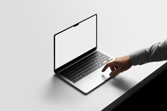 A person interacts with a laptop computer mockup on a sleek, minimalist desk. Isolated blank mockup surface to place your design. 