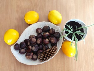 Yellow lemons and shiny brown chestnuts on the table