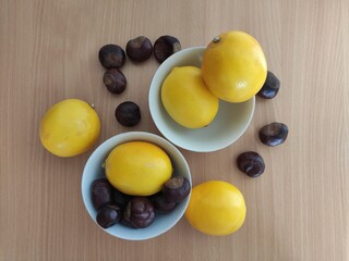 Yellow lemons and shiny brown chestnuts on the table