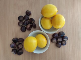 Yellow lemons and shiny brown chestnuts on the table