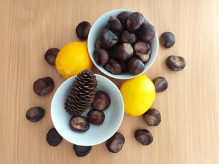 Yellow lemons and shiny brown chestnuts on the table