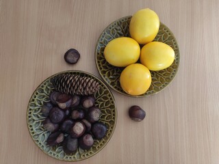 Yellow lemons and shiny brown chestnuts on the table