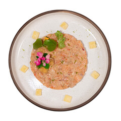 A colorful dish featuring a blend of salmon tartare, garnished with herbs and edible flowers, presented elegantly on a round plate.