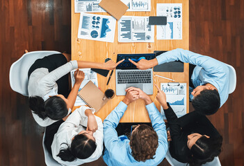 Panorama top view diverse group of business analyst team analyzing financial data report paper on meeting table. Chart and graph dashboard by business intelligence analysis. Meticulous