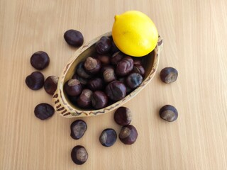 Yellow lemons and shiny brown chestnuts on the table