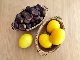 Yellow lemons and shiny brown chestnuts on the table