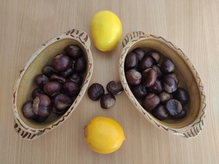 Yellow lemons and shiny brown chestnuts on the table