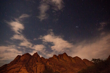 Night photography taken with long exposure times of a hill in Namibia with clouds creating a blur effect