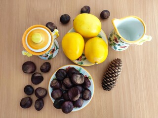 Yellow lemons and shiny brown chestnuts on the table