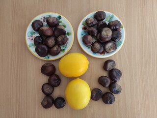 Yellow lemons and shiny brown chestnuts on the table