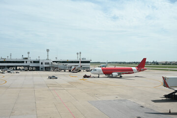 Airport Runway and Terminal Activity, A view of the airport terminal showcasing parked aircraft, ground vehicles, and jet bridges, highlighting the operations and logistics of air travel