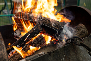 Burning wood. Flame fire sparks on dark abstract background. Cooking barbecue outdoor. Hellish fire element. Fuel, power and energy.