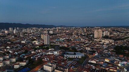 Obraz premium Foto aérea de Mogi das Cruzes, SP, Brasil, à noite, destacando a iluminação da cidade, com tráfego urbano e a atmosfera vibrante da cidade paulista