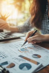 Analyzing financial data with focus and precision. Graphs and charts on paper highlight key trends and metrics, creating a professional atmosphere in a corporate setting