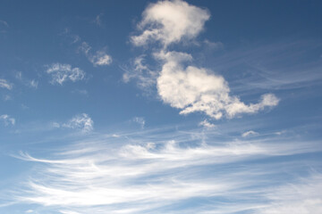 Obraz premium White cirrus clouds in the blue autumn sky