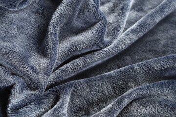A close-up view of gray fabric with soft folds, showcasing the texture and details, ideal for...