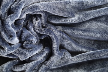 A close-up view of gray fabric with soft folds, showcasing the texture and details, ideal for...