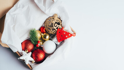 Box with Christmas shiny toys. Red and gold balls and New Year's baubles. Christmas greeting background, greeting card. Copy space