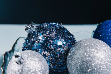 Close-up of Christmas tree decorations. Blue and silver balloons and baubles. Holiday and New Year concept. Idea for a card or poster.