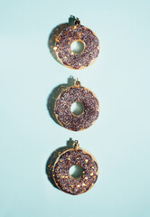 Christmas decoration baubles made of donut with lights on a blue background. Holiday and New Year concept. Idea for a card or poster. Vertical