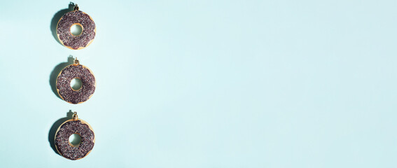 Banner. Christmas decoration baubles made of donut on a blue background. Holiday and New Year concept.