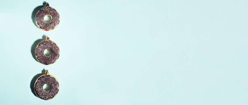 Banner. Christmas decoration baubles made of donut on a blue background. Holiday and New Year concept.