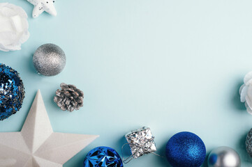 Blue and silver Christmas toys on a blue background. Christmas decorations. Copy space, flat lay