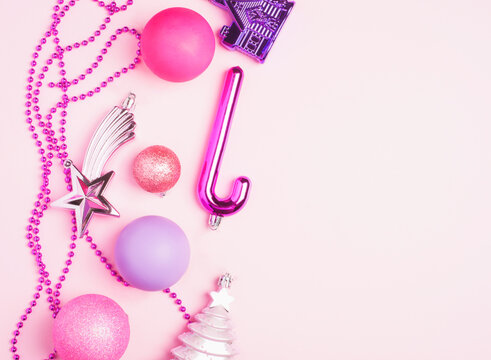 Pink and purple Christmas toys on a blue background. Christmas decorations. Copy space, flat lay