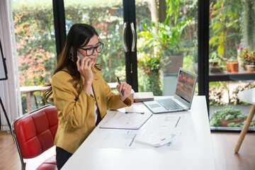 Businesswoman holding a phone talking about a housing development project