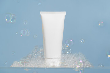 White mockup tube of cream, lotion or foam for cleansing and moisturizing the skin on a blue...