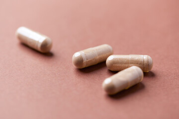Reishi capsules. Concept for a healthy dietary supplementation. Paper background. Soft focus. Close up.	