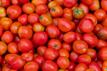 Pile of ripe and delicious red cherry tomatoes, a small round variety of tomato that is nutritionally valuable.