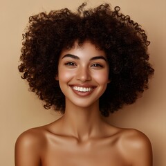 A woman with natural curly hair smiles warmly against a soft beige background