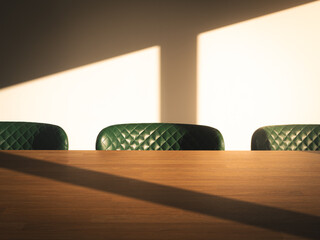 Warm morning light casts shadows over a wooden kitchen table and three green chairs
