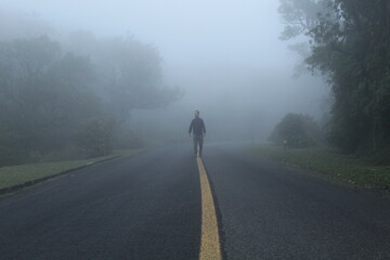 silhueta de homem caminhando em estrada com neblina  - na estrada da graciosa, paraná 