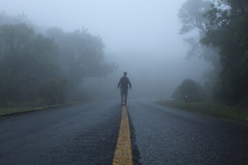 silhueta de homem caminhando em estrada com neblina  - na estrada da graciosa, paraná 