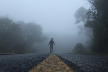silhueta de homem caminhando em estrada com neblina  - na estrada da graciosa, paraná 
