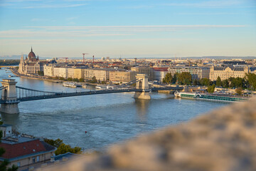 A stunning daytime view of Budapest from above, with the iconic Fisherman's Bastion and the Parliament Building framing the city’s dynamic skyline