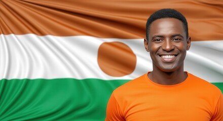 Portrait of smiling man in orange shirt with niger flag background for cultural diversity theme