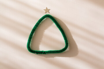 Christmas composition. Christmas tree made from fluffy green wire on a white background. Flat lay, top view, copy space. New Year holiday card