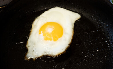 Fried egg in a frying pan. Cooking scrambled eggs.