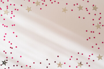 Christmas Holiday Festive border frame. Pink shiny stars on a white background. Flat lay, top view, copy space. New Year holiday card