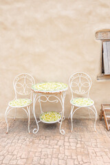 Metal table and chair inside desert House or hotel with cactus and blue sky,villa house building facade exterior mediterranean architecture in desert,selective focus..