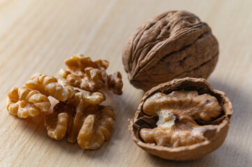 Shelled walnuts, kernels next to in-shell walnuts and nutcrackers. Production, consumption of walnuts, nutrition and properties of walnuts.