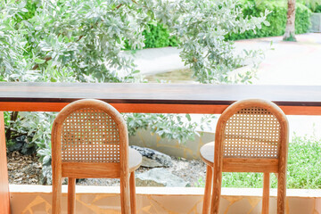Wicker chair and wooden table in restaurant,Rattan chair in scandinavian interior of living room,Mediterranean minimal wall and green plant exterior architecturer,warm beige tones,copy space.