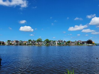 Scenic Lakeside View Showcasing Charming Houses and Clear Blue Skies in a Tranquil Setting