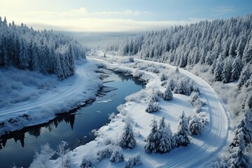 Obraz premium Winding windy road in a snowy forest with a river flowing nearby.