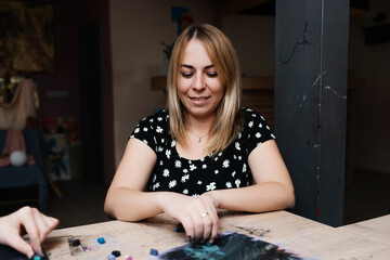 Fototapeta premium Woman creating art with pastels in a bright studio during the day