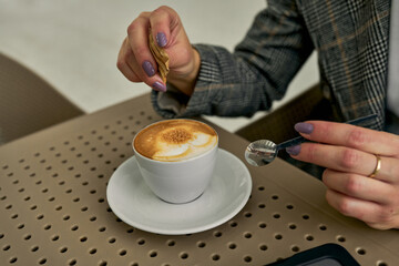 With a joyful spirit, a caucasian businesswoman relishes her coffee at the train station cafe.