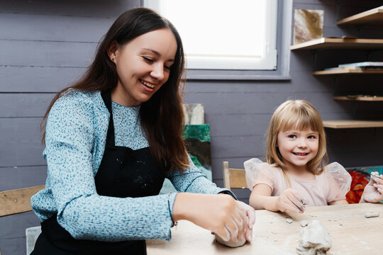 Creative mother and daughter enjoy pottery at home during a sunny afternoon